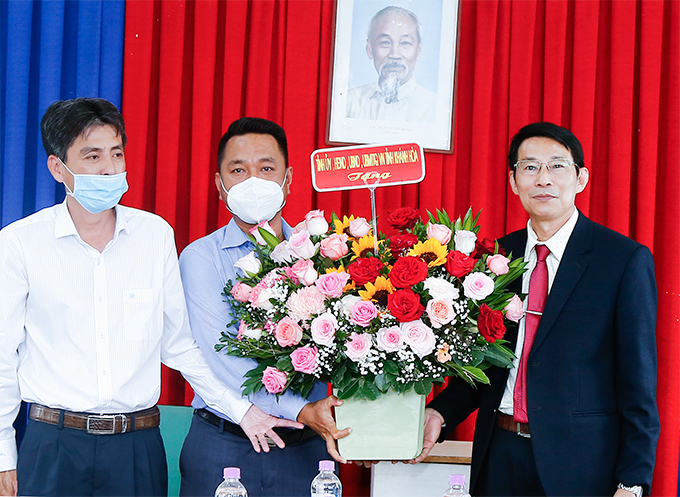 Ông Đinh Văn Thiệu (bìa phải) tặng hoa chúc mừng đầu xuân cho Ban Quản lý cảng cá Hòn Rớ