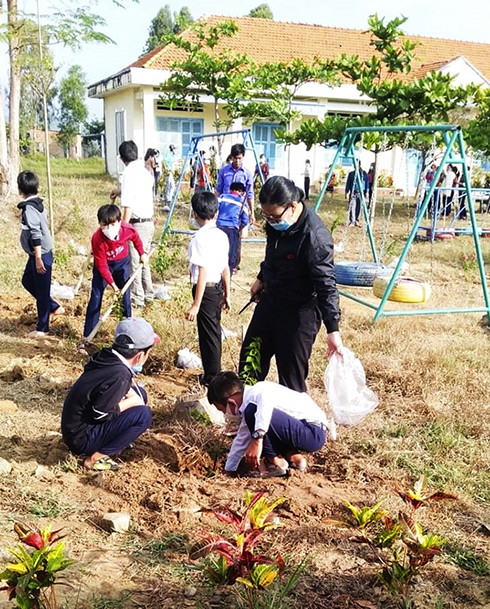 Hội viên phụ nữ xã Ninh Trung cùng học sinh trồng cây.