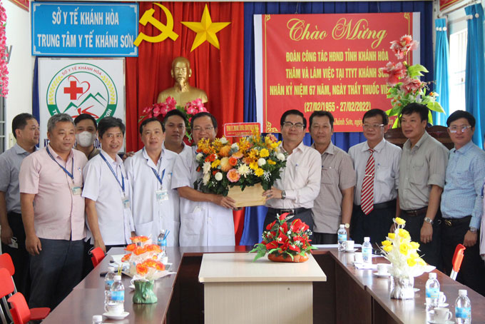 Ông Trần Mạnh Dũng tặng hoa chúc mừng tập thể Trung tâm Y tế huyện Khánh Sơn.