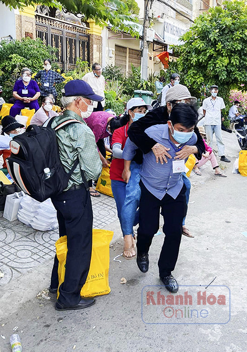 Tình nguyện viên Hội Chữ thập đỏ Ninh Hòa cõng người bệnh lên xe chuẩn bị ra về.