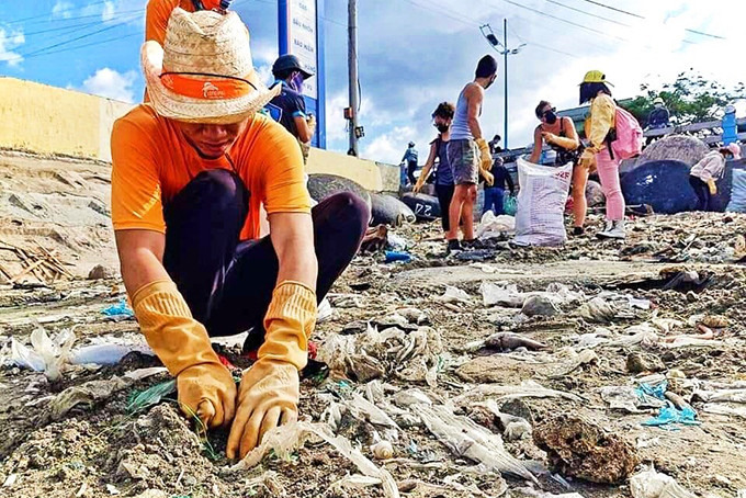 Một thành viên trong nhóm tham gia nhặt rác tại bờ biển xã Vĩnh Lương. 