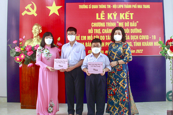 Cán bộ Hội Liên hiệp Phụ nữ TP. Nha Trang trao học bổng cho 2 học sinh có cha mất do dịch Covid-19. 
