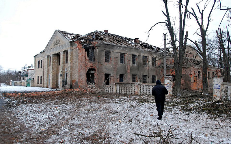 Người đàn ông đứng trước một tòa nhà bị pháo kích tại Kharkiv, Ukraine, ngày 6/3. (Ảnh: Reuters)