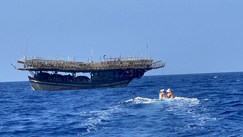Lực lượng cứu nạn sử dụng xuồng để tiếp cận tàu cá có thuyền viên bị nạn
