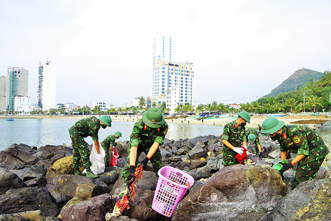 Các cán bộ, đoàn viên tích cực thu gom rác trên bãi biển.