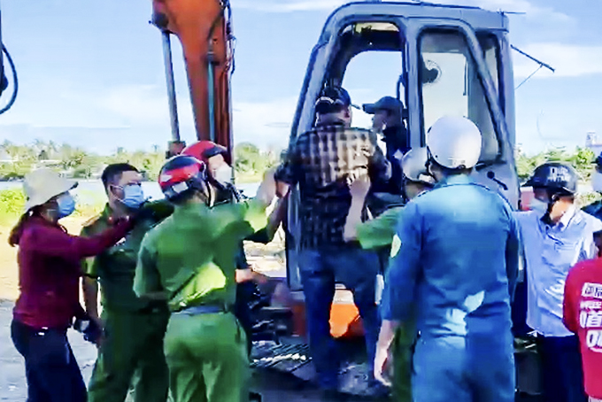 Các đối tượng leo lên xe máy múc đe dọa tài xế, ngăn cản lực lượng chức năng  làm nhiệm vụ tại thôn Xuân Ngọc trong chiều 22-3.  Ảnh do UBND xã Vĩnh Ngọc cung cấp