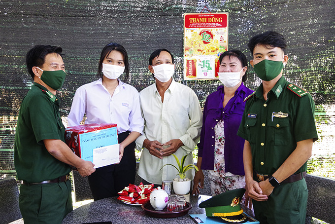 Cán bộ, chiến sĩ Đồn Biên phòng Cam Hải Đông trao học bổng cho một học sinh  nhận đỡ đầu tại xã Cam Hòa, huyện Cam Lâm.