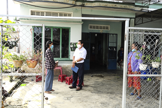 Đại diện Bảo hiểm xã hội huyện Cam Lâm vận động người dân thôn Đồng Cau, xã Suối Tân tham gia bảo hiểm y tế.