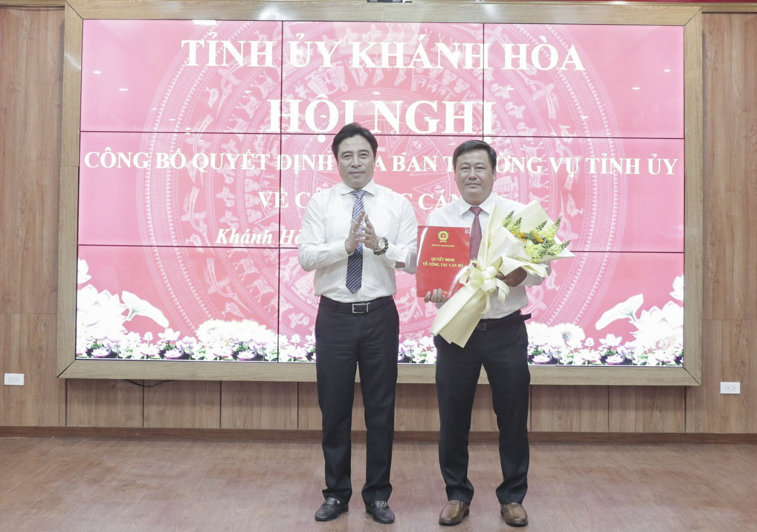 Ông Nguyễn Khắc Toàn trao quyết định và tặng hoa chúc mừng ông Trần Gia Văn.