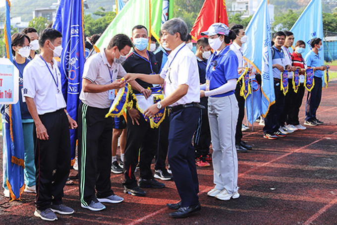 Leader of Khanh Hoa Provincial Department of Education and Training giving souvenir flags to participating units