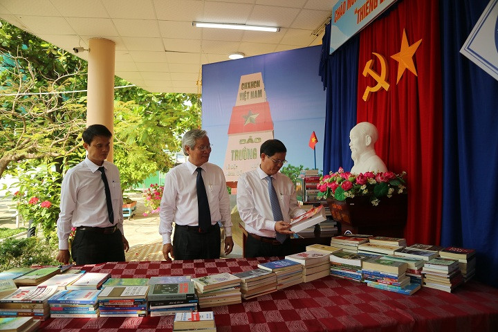Ông Nguyễn Tấn Tuân cùng lãnh đạo Sở Giáo dục và Đào tạo Khánh Hòa, lãnh đạo nhà trường tham quan khu trưng bày sách. 