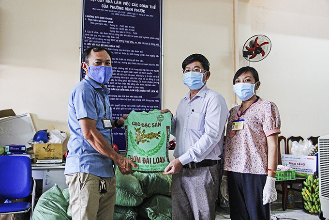 Ông Lê Hoàng Triều - Phó Tổng Biên tập  Báo Khánh Hòa tặng gạo cho phường Vĩnh Phước, TP. Nha Trang.