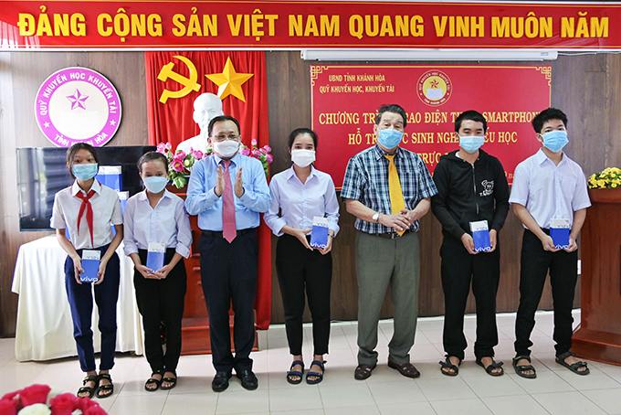  Ông Lê Hữu Hoàng - Phó Chủ tịch Thường trực UBND tỉnh và lãnh đạo Quỹ Khuyến học, khuyến tài tỉnh trao điện thoại thông minh cho học sinh nghèo hiếu học. Ảnh: V.Thành