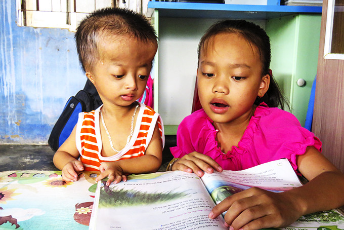 Bé Sang cùng chị ôn bài tại nhà.