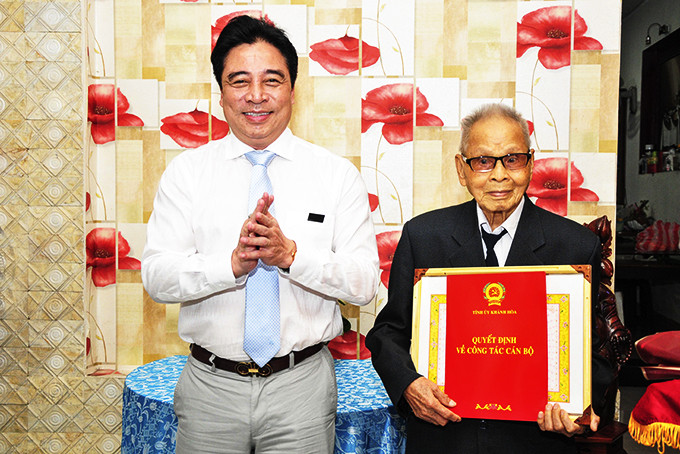 Ông Nguyễn Khắc Toàn  trao Huy hiệu  75 năm tuổi Đảng  cho đồng chí Dương Chí.