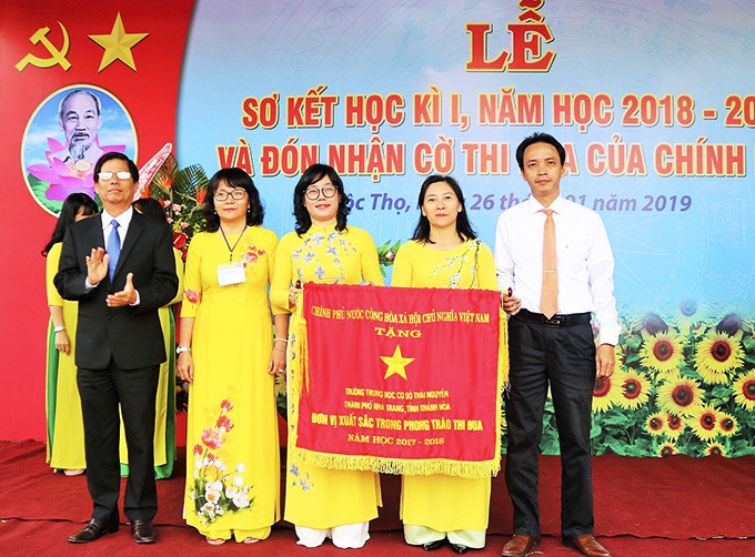 Ông Nguyễn Tấn Tuân - Phó Bí thư Tỉnh ủy, Chủ tịch UBND tỉnh trao cờ thi đua của Chính phủ cho nhà trường.