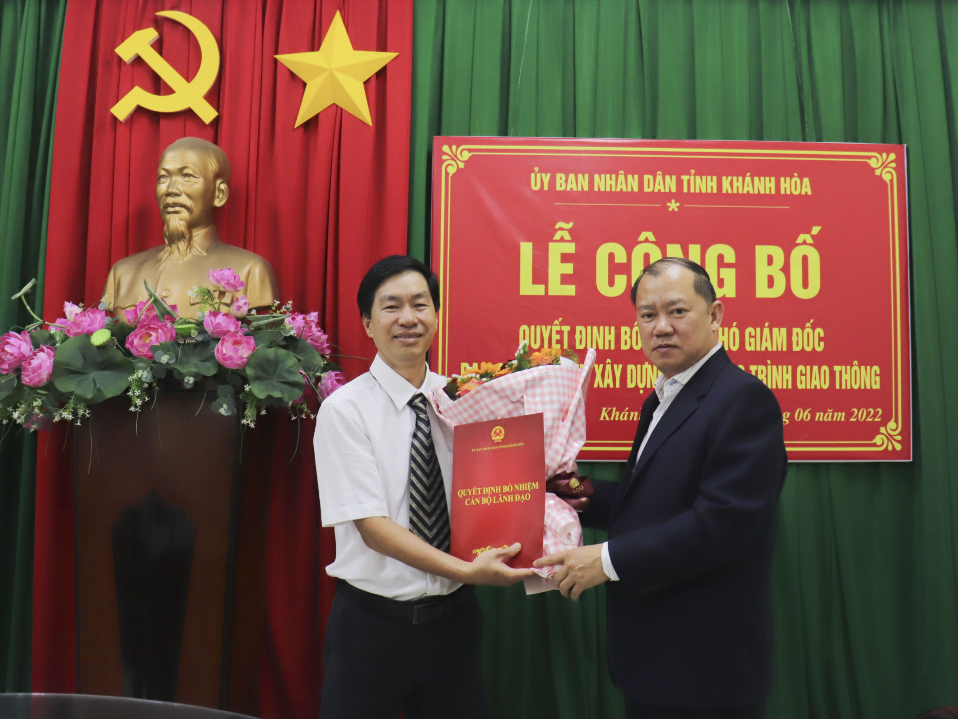 Ông Nguyễn Anh Tuấn (bìa phải) trao quyết định, tặng hoa cho ông Phạm Văn Hòa.