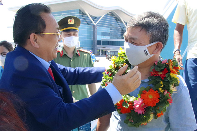 Le Huu Hoang gives flowers to passengers on Singapore - Cam ranh flight