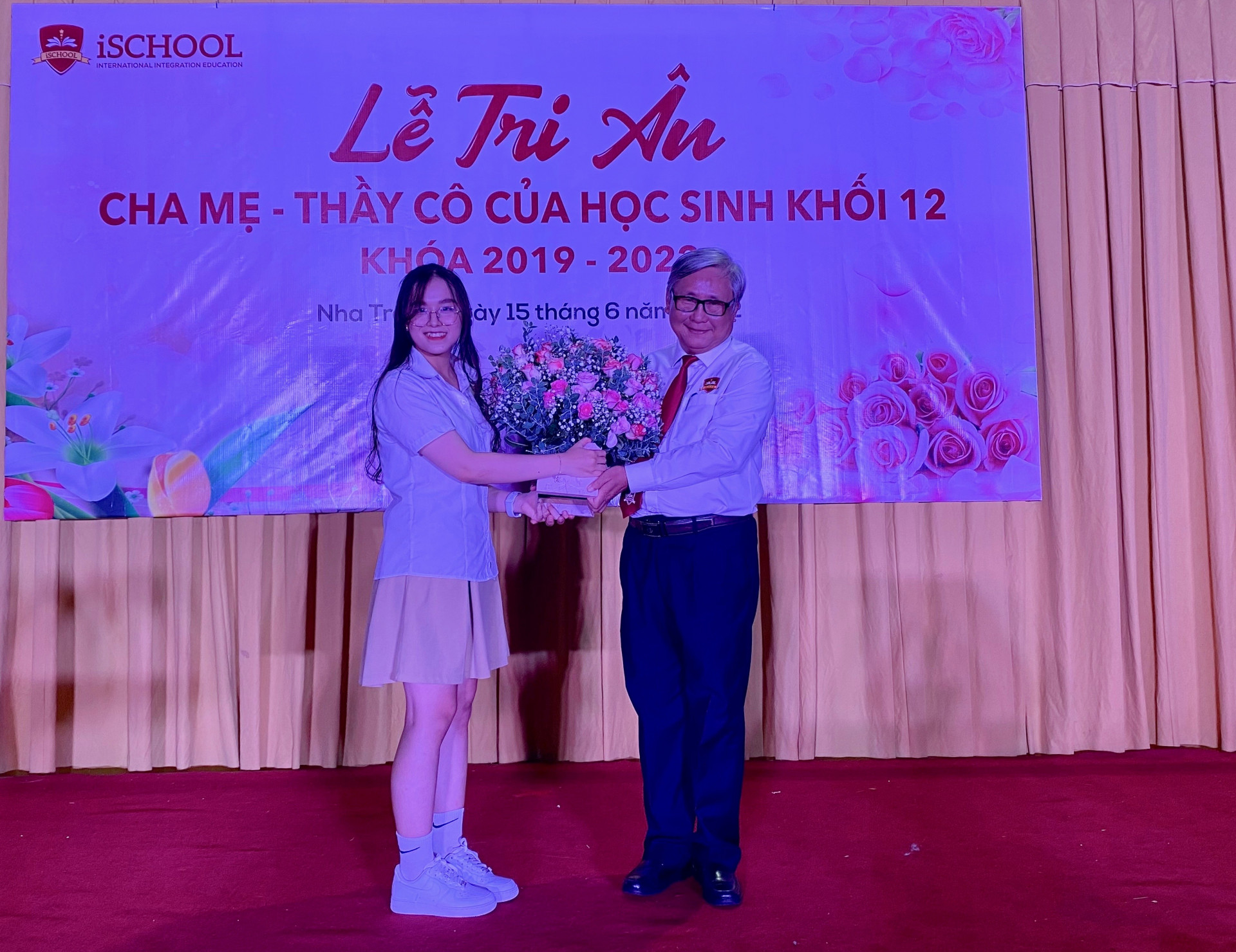 Thầy Phạm Hữu Bình nhận hoa của đại diện các học sinh khối 12.