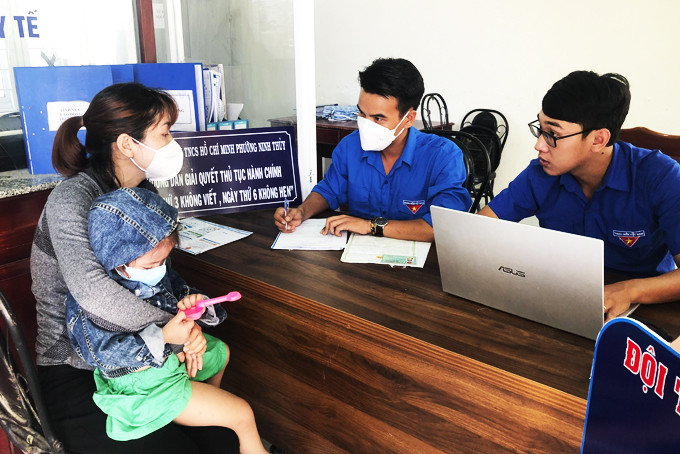 Cán bộ đoàn phường Ninh Thủy hướng dẫn, hỗ trợ người dân viết tờ khai thực hiện thủ tục hành chính.