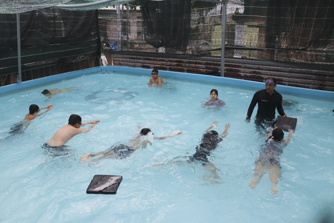 Các bạn nhỏ học bơi tại bể bơi di động  ở Nhà văn hóa thôn Xuân Lạc (xã Vĩnh Ngọc).
