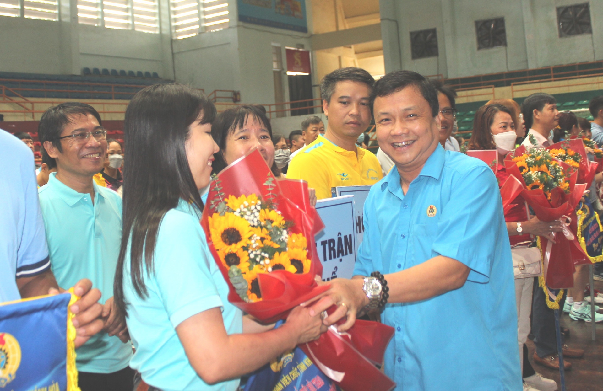 Representative of Khanh Hoa Labor Federation offering flowers and souvenir flags to teams