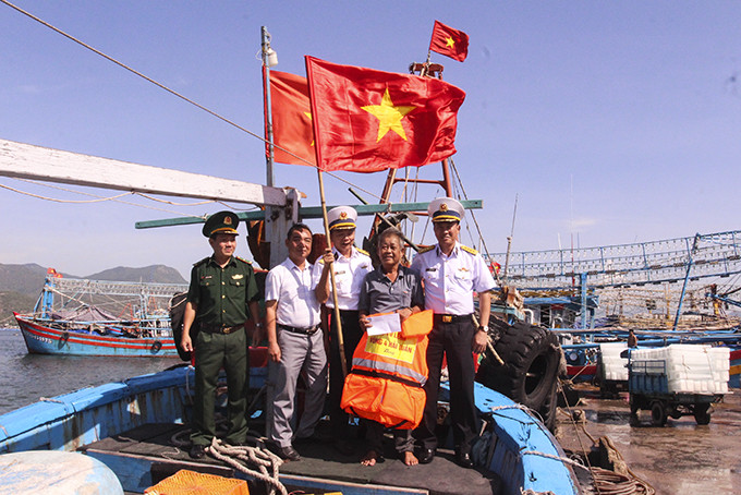 Đại diện Vùng 4 Hải quân tặng cờ Tổ quốc và quà cho ngư dân TP. Cam Ranh.