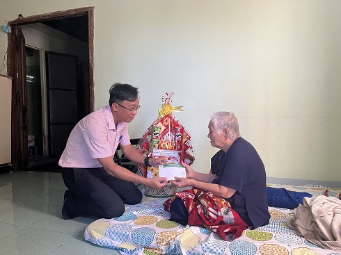 Cán bộ NHCSXH tỉnh Khánh Hòa tặng quà cho bà Lê Thị Bèo, xã Cam Hải Tây, huyện Cam Lâm.