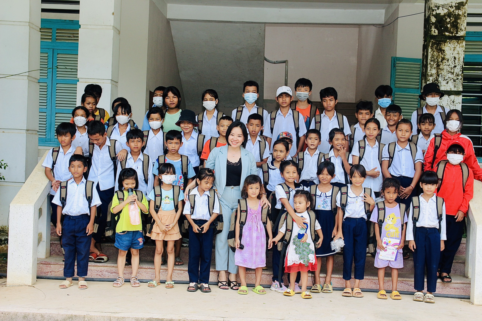 Bà Thái Thị Lệ Hằng - Phó Tổng biên tập Báo Khánh Hòa trao tặng ba lô cho các em học sinh.