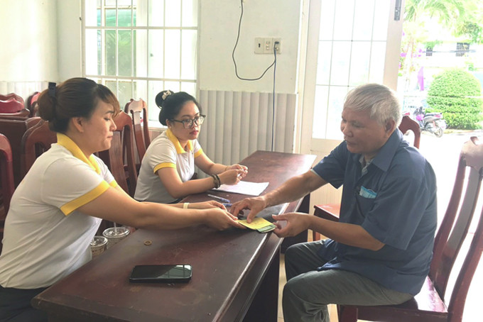 Nhân viên  bưu điện chi trả  trợ cấp  cho người có công với cách mạng phường Lộc Thọ.