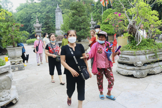 Người bán hàng rong đeo bám du khách ở chùa Long Sơn chiều 9-8-2022.