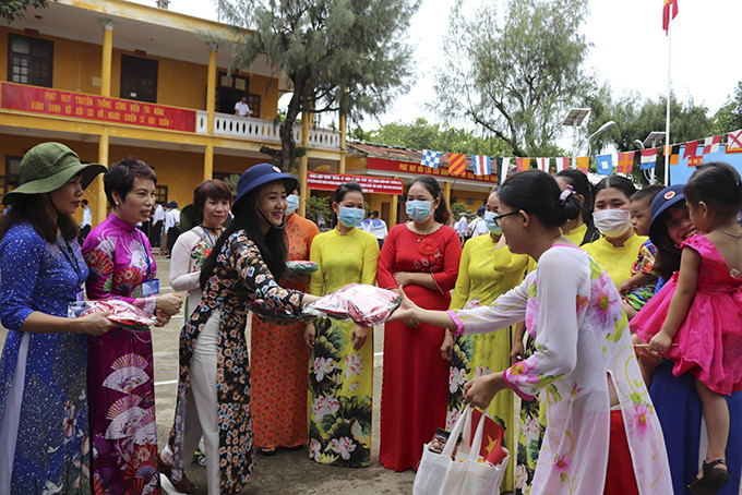 Bà Nguyễn Quỳnh Nga (trái) trao tặng áo dài cho phụ nữ trên đảo Sinh Tồn.
