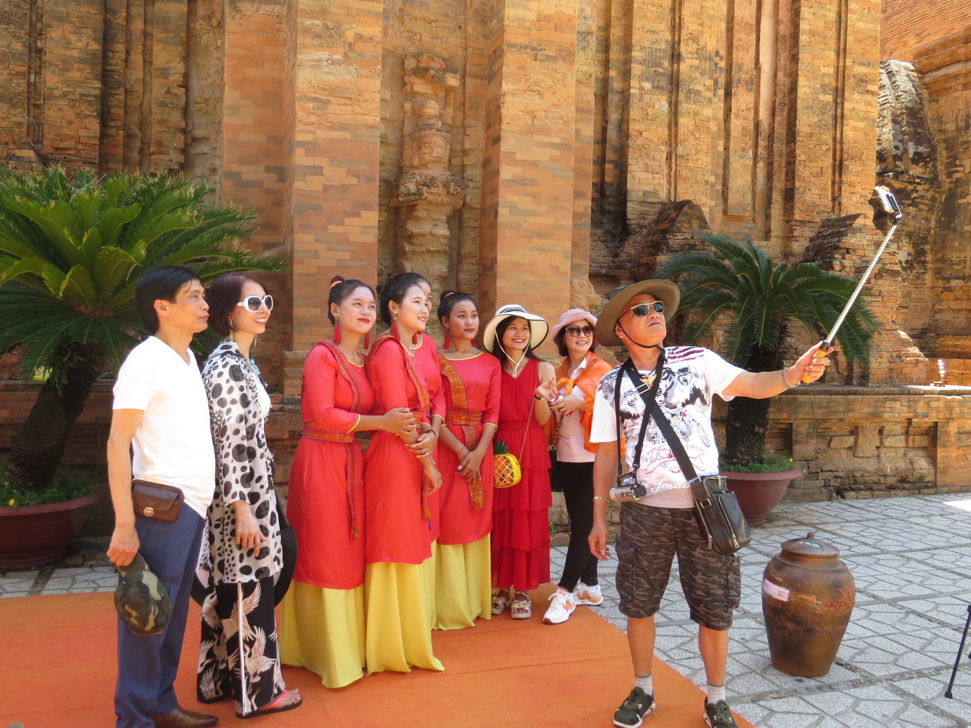 Khách du lịch chụp ảnh lưu niệm với các diễn viên biểu diễn các điệu múa truyền thống của dân tộc Chăm ở Khu di tích Tháp Bà Ponagar.