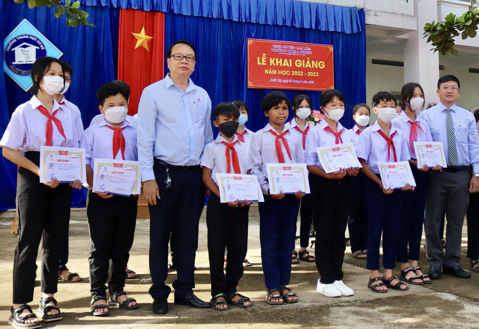 Lãnh đạo Báo Khánh Hòa và lãnh đạo Công ty TNHH Long Sinh trao học bổng cho học sinh.