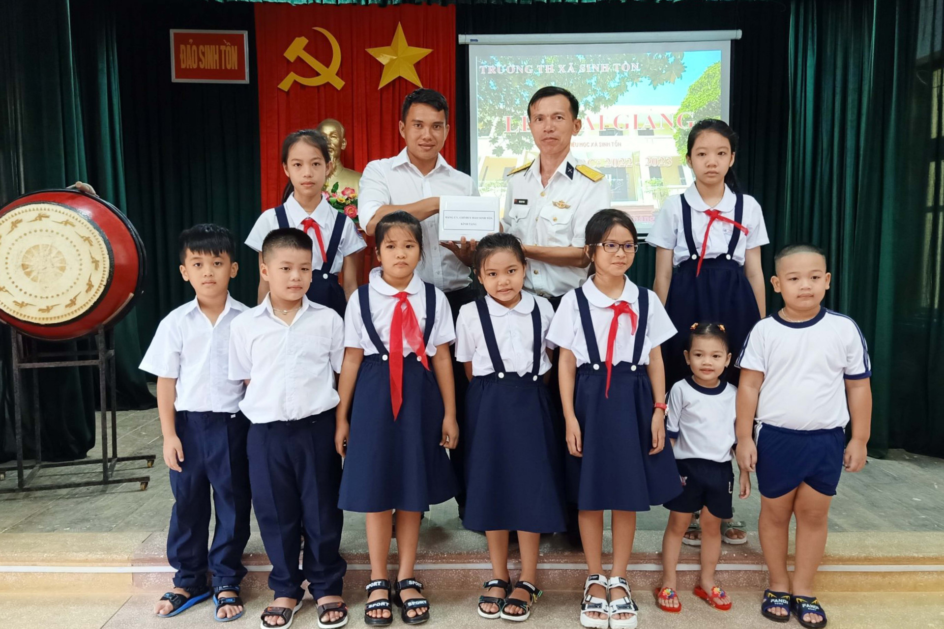 Đại diện chỉ huy đảo Sinh Tồn tặng quà cho các học sinh Trường Tiểu học Sinh Tồn tại lễ khai giảng năm học mới