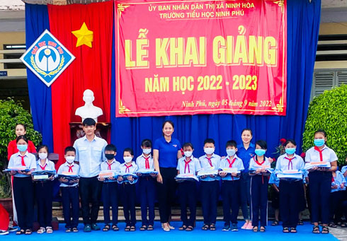 Đại diện Công đoàn cơ sở và Chi đoàn Công ty Cổ phần Du lịch Long Phú tặng quà cho các em học sinh tại trường Tiểu học Ninh Phú.