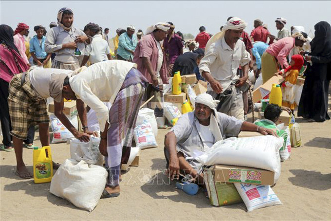 Người dân nhận hàng cứu trợ tại một trại tị nạn ở thành phố Hodeidah, Yemen ngày 31/8/2022. Ảnh: AFP/TTXVN