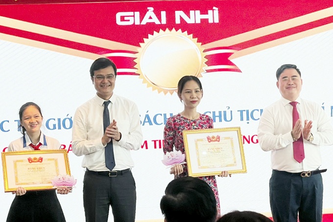 Em Lê Ngọc Minh Châu (bìa trái) nhận giải cuộc thi giới thiệu sách về Chủ tịch Hồ Chí Minh.