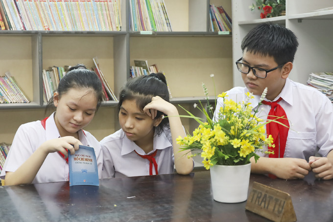 Em Lê Ngọc Minh Châu (bìa trái) đọc sách với các bạn cùng lớp.