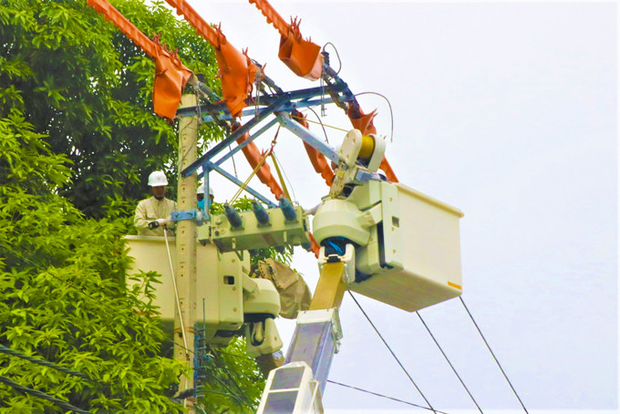 Electrical staff repairing and reinforcing power lines before rainy season