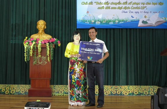 Đại diện Thư viện tỉnh Khánh Hòa (bên trái) tặng sách cho nhà trường. 