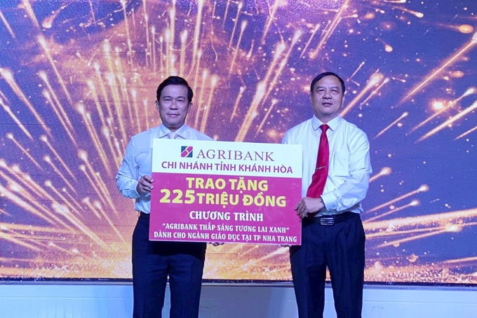 Ông Nguyễn Thanh Bình (bên phải) trao tượng trưng số tiền 225 triệu đồng cho lãnh đạo Phòng Giáo dục và Đào tạo TP. Nha Trang. Ảnh: KIM DUNG