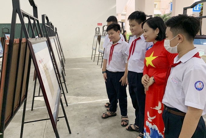 Giáo viên, học sinh Trường THCS Trần Nhật Duật xem hình ảnh triển lãm. 
