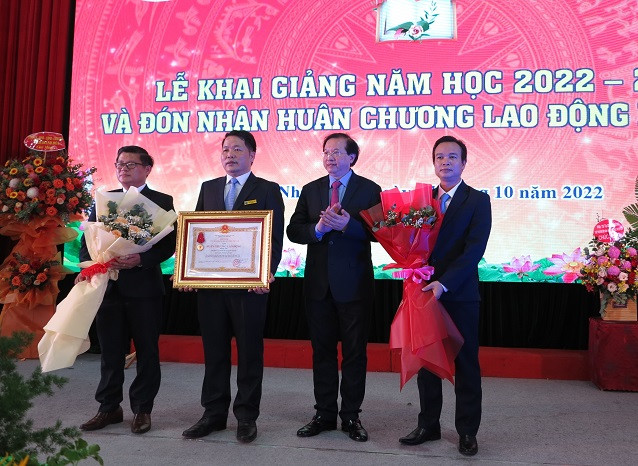 Thừa ủy quyền của Chủ tịch nước, ông Tạ Quang Đông trao Huân chương Lao động hạng Nhì cho nhà trường.