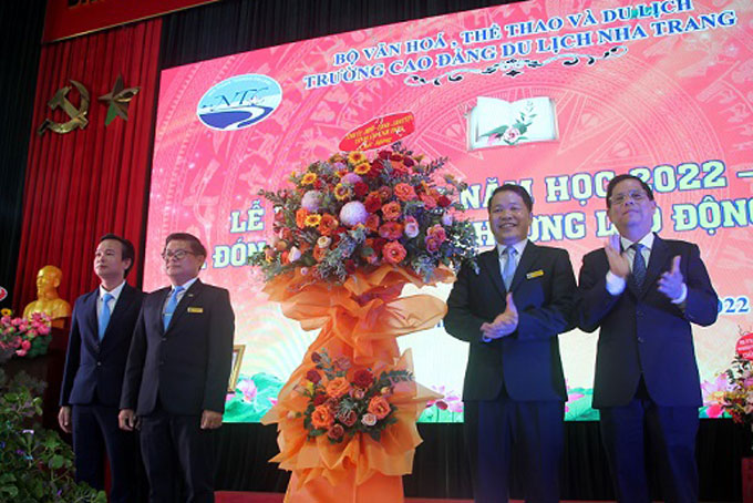 Ông Nguyễn Tấn Tuân tặng hoa chúc mừng nhà trường.