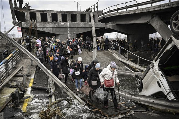 Người dân sơ tán khỏi thành phố Irpin, tây bắc thủ đô Kiev, Ukraine, ngày 5/3/2022. Ảnh: AFP/TTXVN