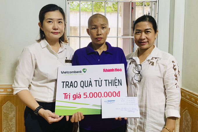 Đại diện Báo Khánh Hòa và Vietcombank Nha Trang  trao tiền ủng hộ cho chị Phạm Thị Hương.