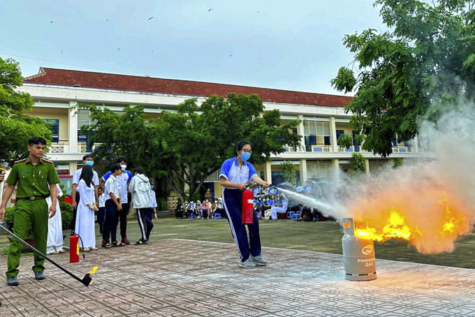 Học sinh Trường THPT Phan Bội Châu (TP. Cam Ranh) thực hành sử dụng bình chữa cháy.