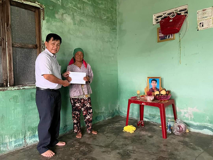Ông Trần Khánh Hoà trao tiền hỗ trợ cho hộ ông Mấu Hạ Xuông.