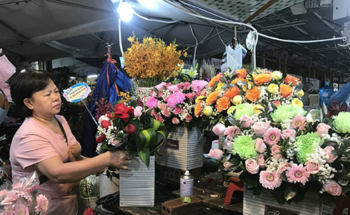 Tranh thủ vắng khách, bà Phan Lê Thanh Nhàn cắm thêm các giỏ hoa